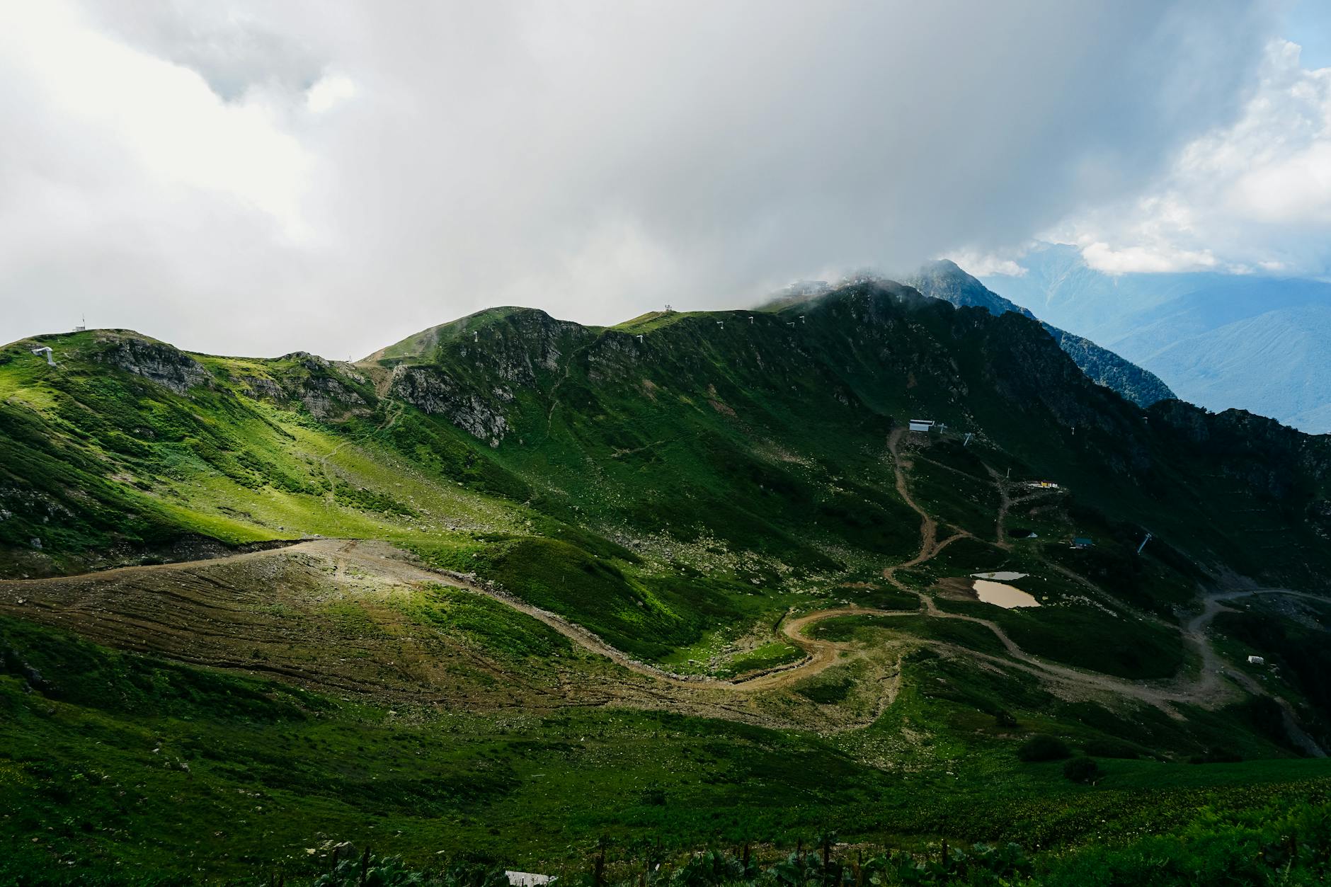 winding rural road on green slope